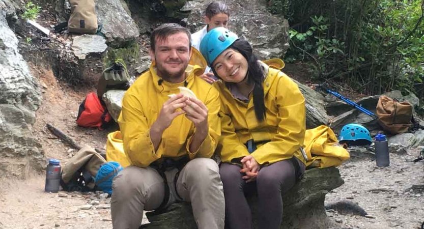 two gap year students rest on a rock on an outward bound expedition in the blue ridge mountains